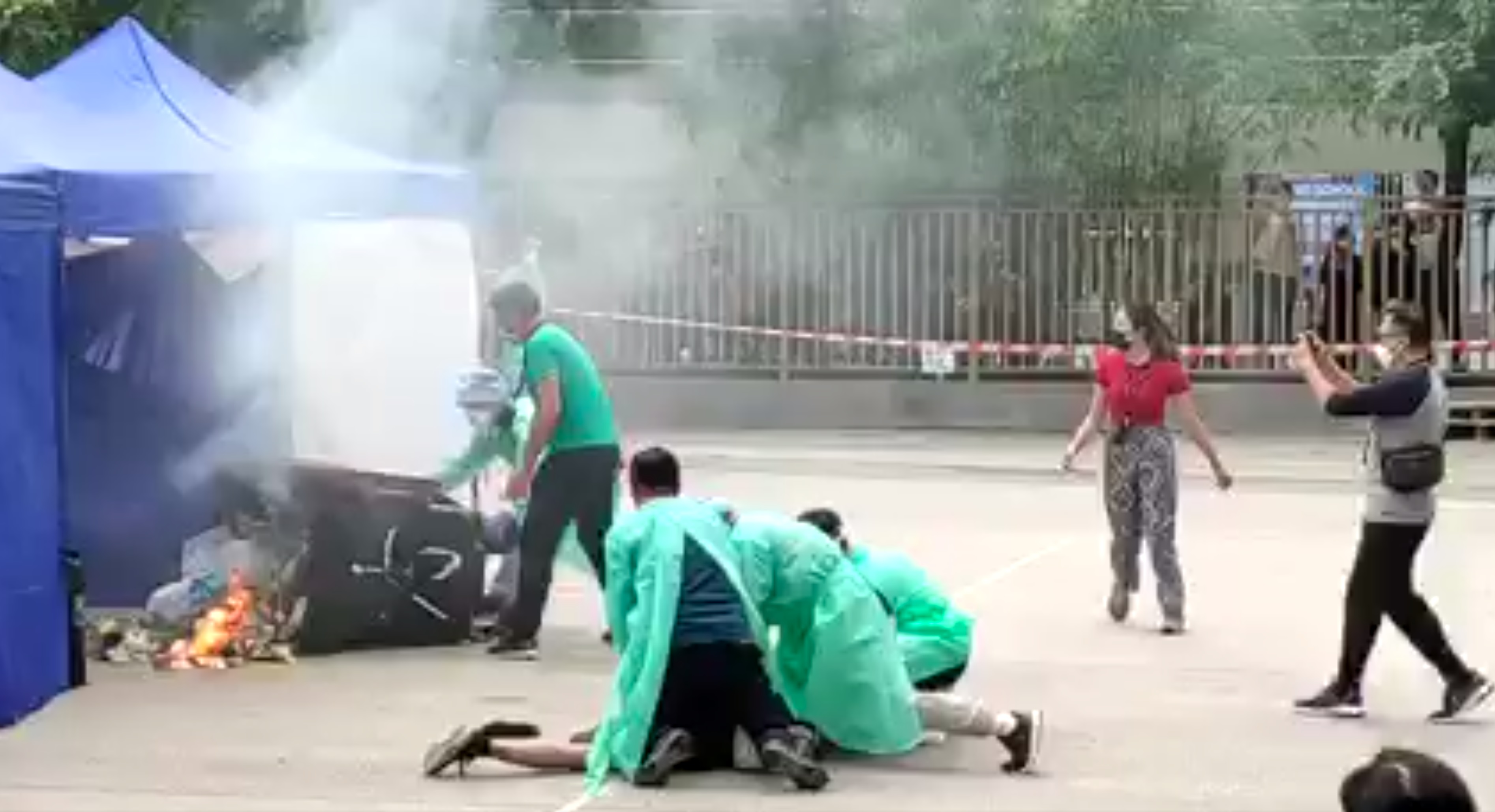 數名穿著保護衣的人員將男子按在地上。(李梓敬fb影片截圖)