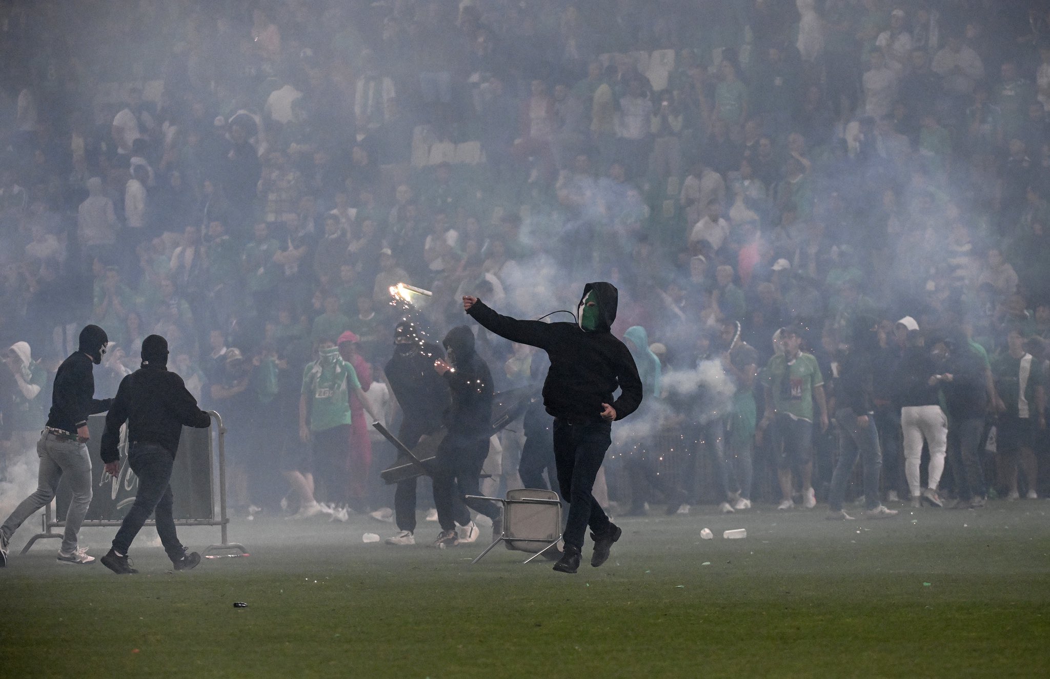 降班的聖伊天球迷，走入球場四處投擲煙火。(Twitter圖片)