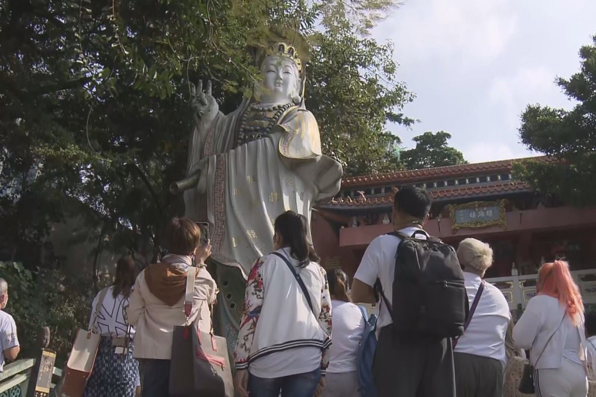 疫情下首個訪港旅行團來自泰國，今日先後到訪淺水灣和紅磡的廟宇。(電視截圖)
