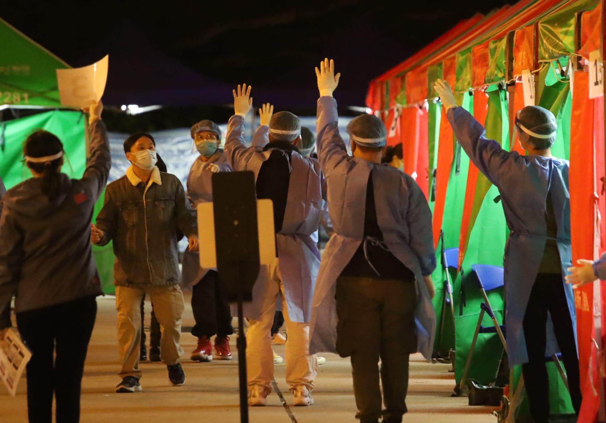 石華樓流動採樣站職員指示居民接受檢測。(鍾式明攝)