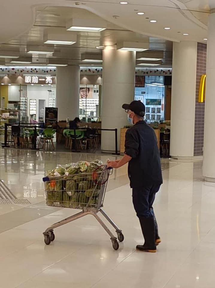 身穿水靴的男子其中一輛手推車的蔬菜堆得密密麻麻。(香港突發報料區@fb圖)