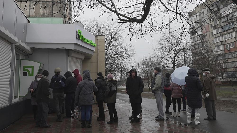 基輔街上有民眾排長龍提取現金。(AP)