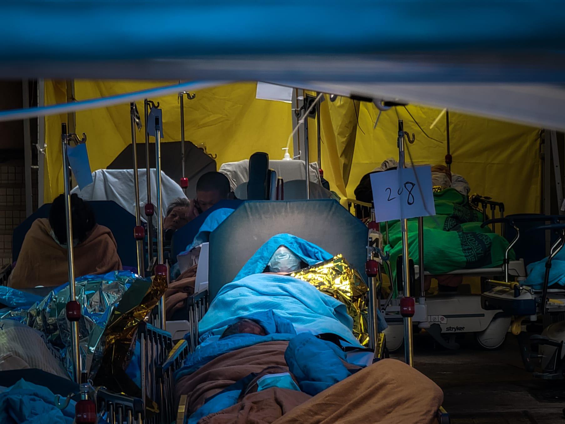 今日氣溫轉冷、有雨,繼續有大批新冠患者在明愛醫院急症室外等候上病房。(莊振邦攝)