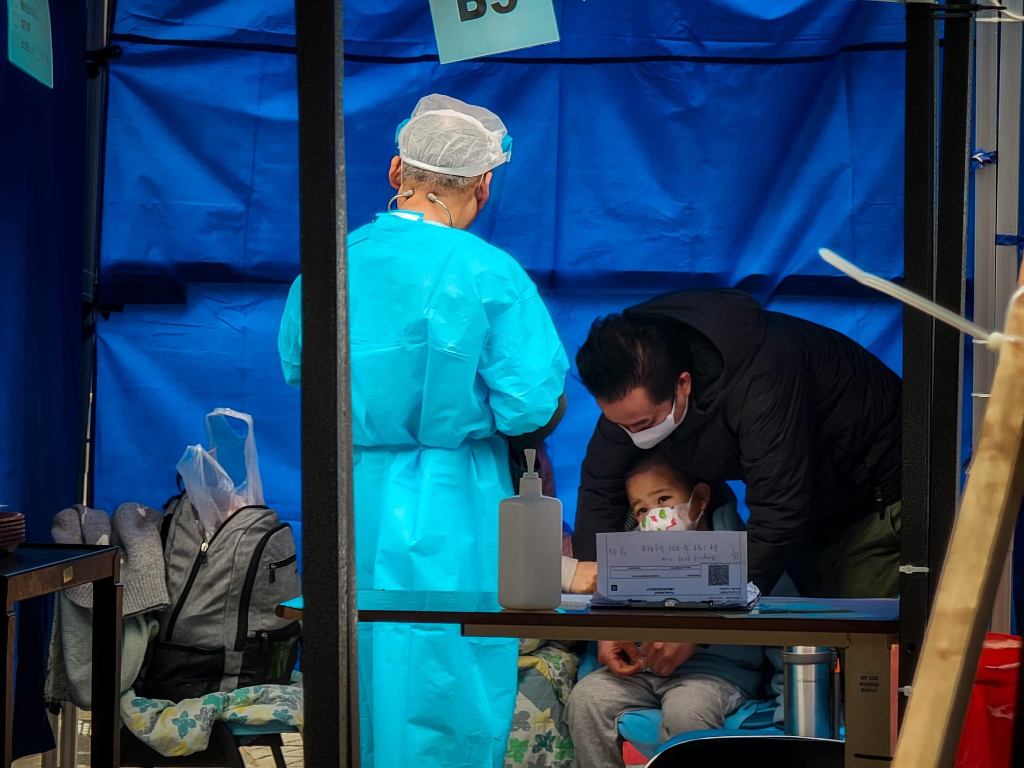 今日氣溫轉冷、有雨,繼續有大批新冠患者在明愛醫院急症室外等候上病房。(莊振邦攝)