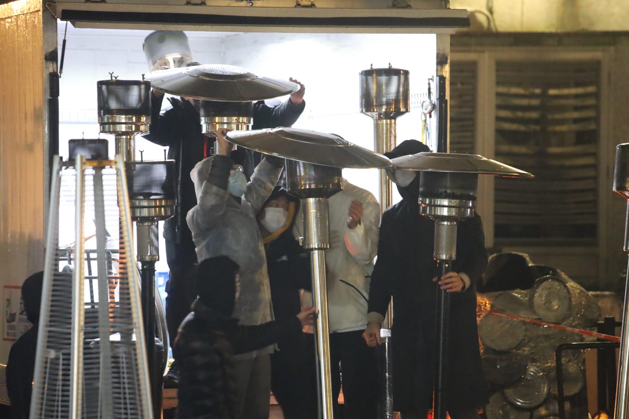 有職員在南昌邨圍封現場架設戶外暖爐。(鍾式明攝)