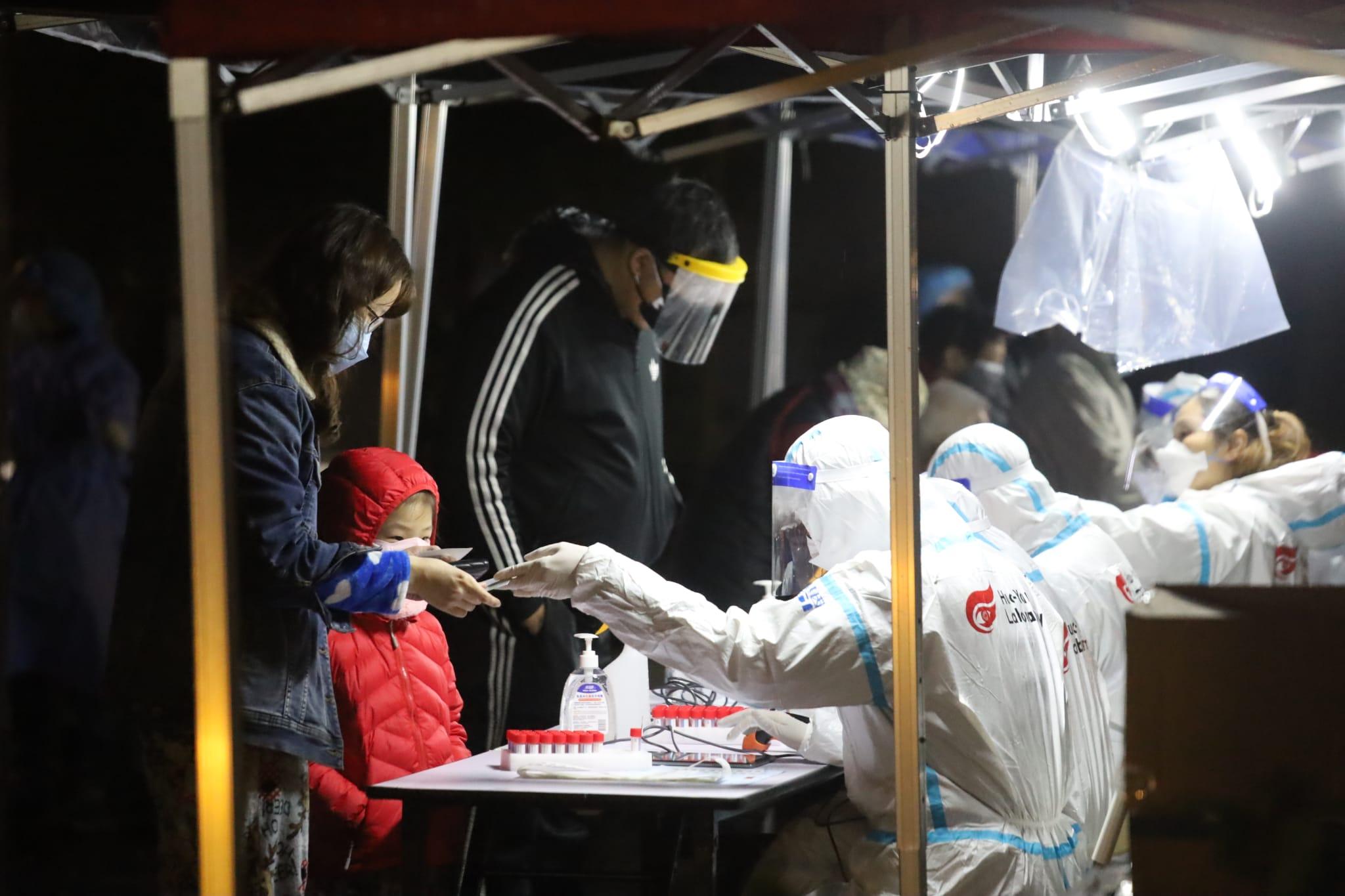 南昌邨圍封行動有工作人員身穿印有「火眼實驗室」標誌的保護衣。(鍾式明攝)