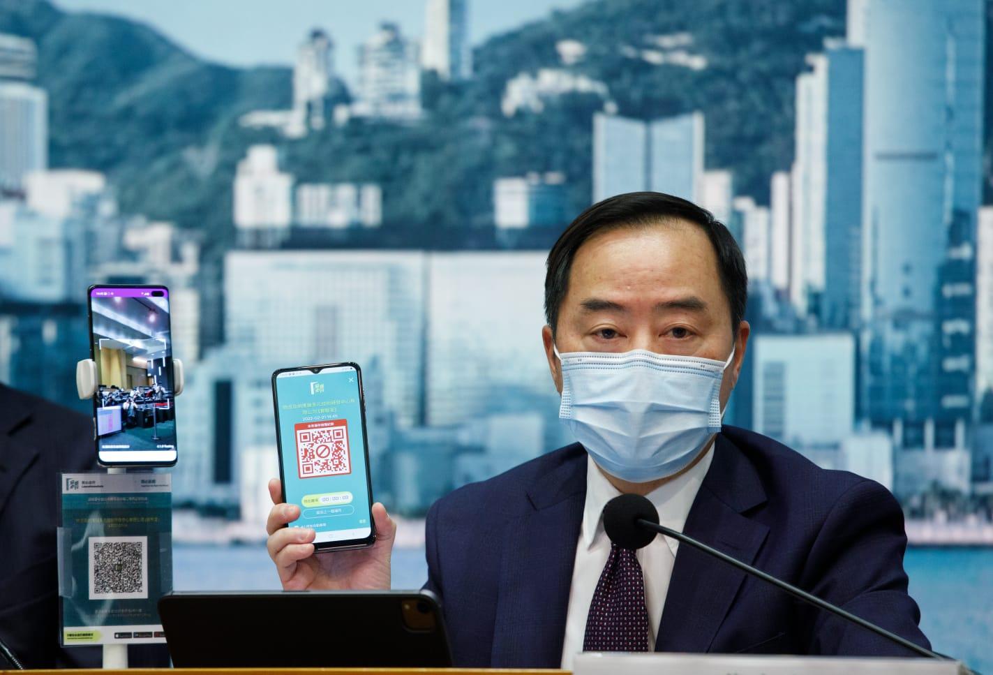 副政府資訊科技總監黃志光,手上電話展示「醫學豁免證明書」。(蘇文傑攝)