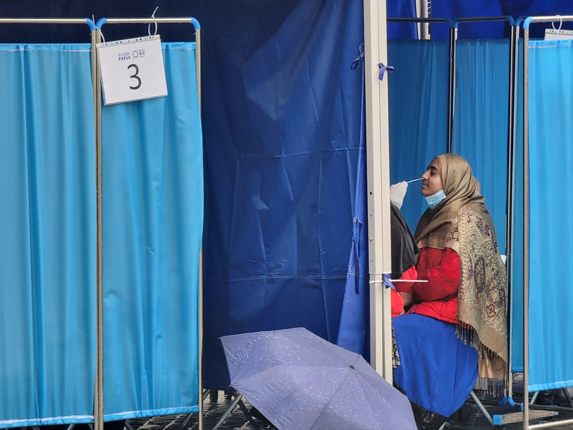 東涌東薈城外今日設置流動採樣站,市民冒雨排隊檢測。(莊振邦攝)