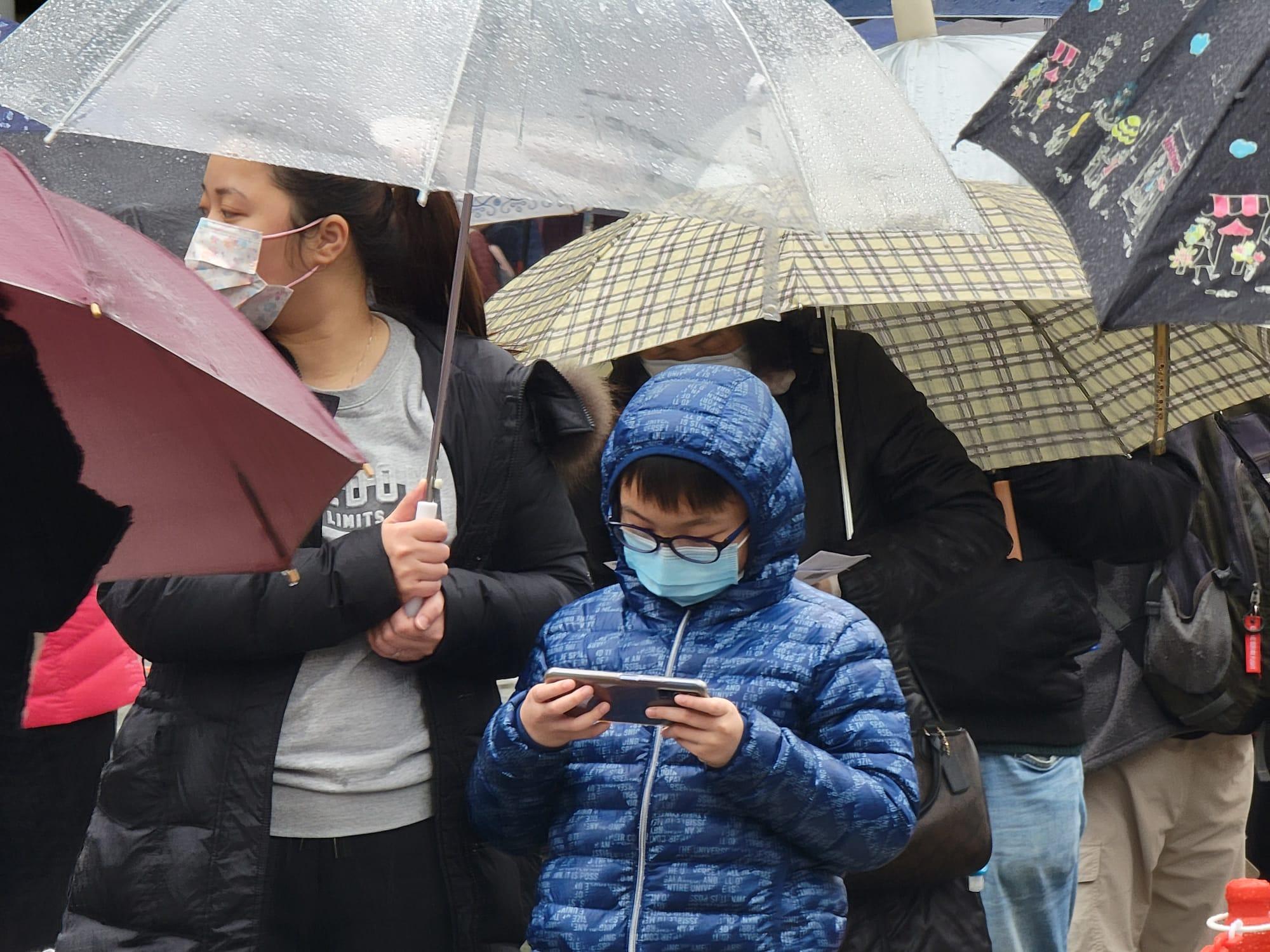 東涌東薈城外今日設置流動採樣站,市民冒雨排隊檢測。(莊振邦攝)