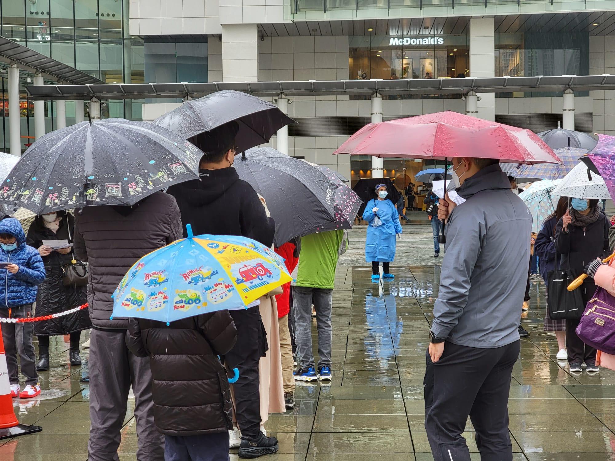 東涌東薈城外今日設置流動採樣站,市民冒雨排隊檢測。(莊振邦攝)