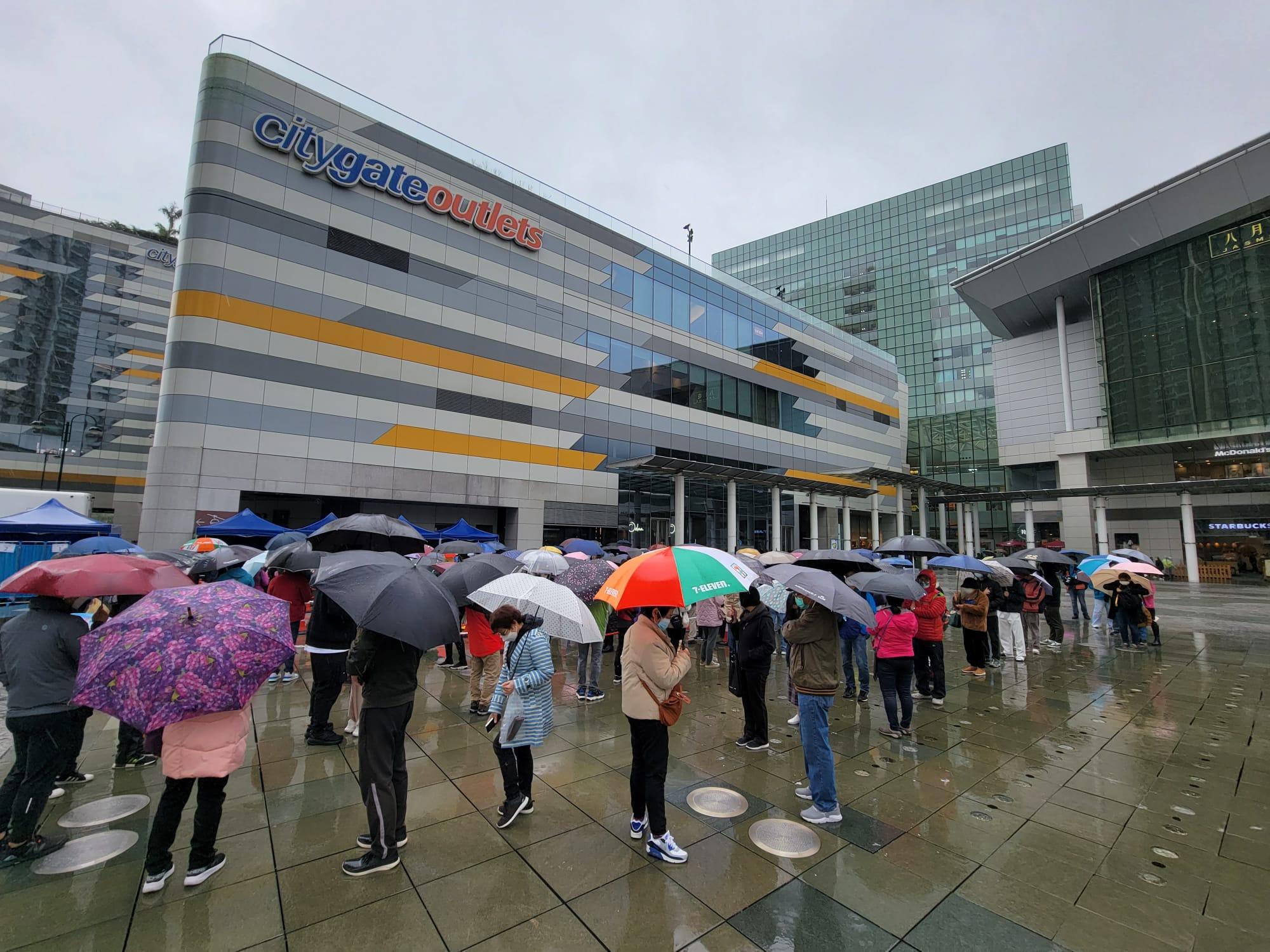 東涌東薈城外今日設置流動採樣站,市民冒雨排隊檢測。(莊振邦攝)