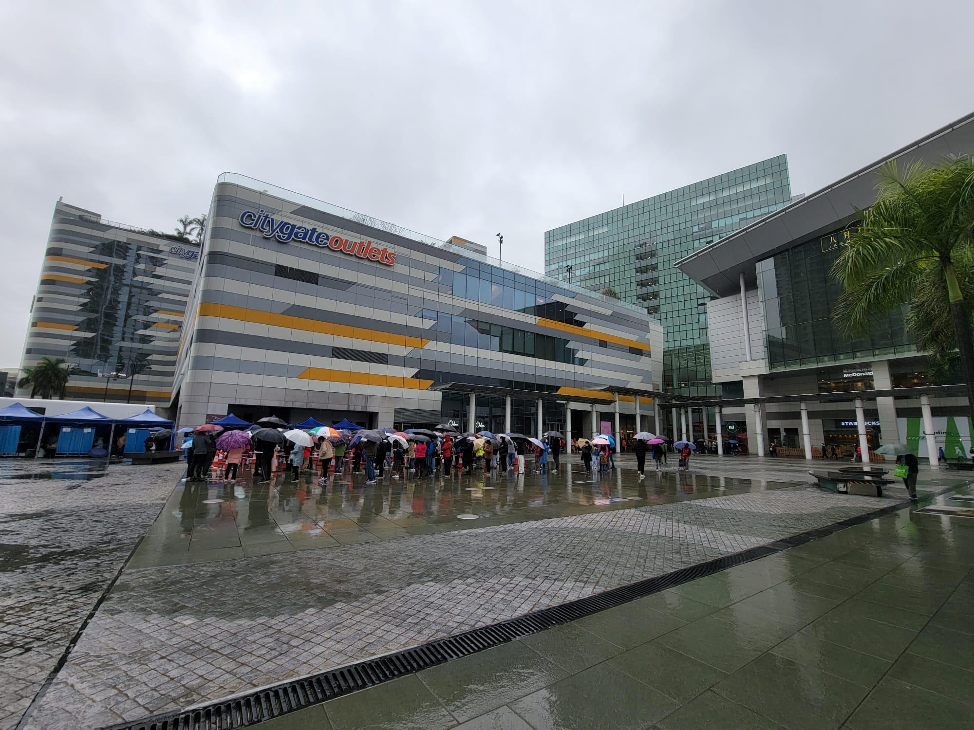 東涌東薈城外今日設置流動採樣站,市民冒雨排隊檢測。(莊振邦攝)