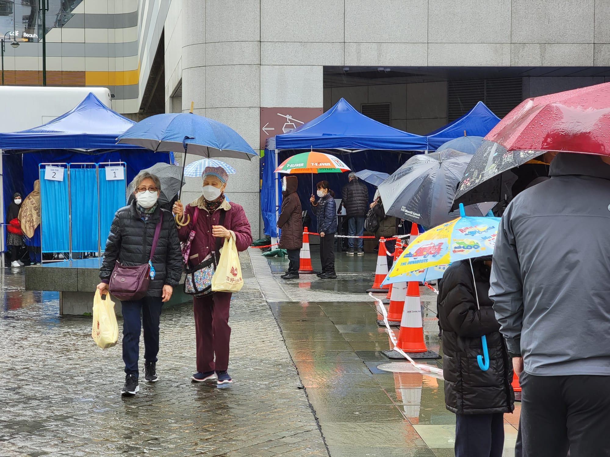 東涌東薈城外今日設置流動採樣站,市民冒雨排隊檢測。(莊振邦攝)