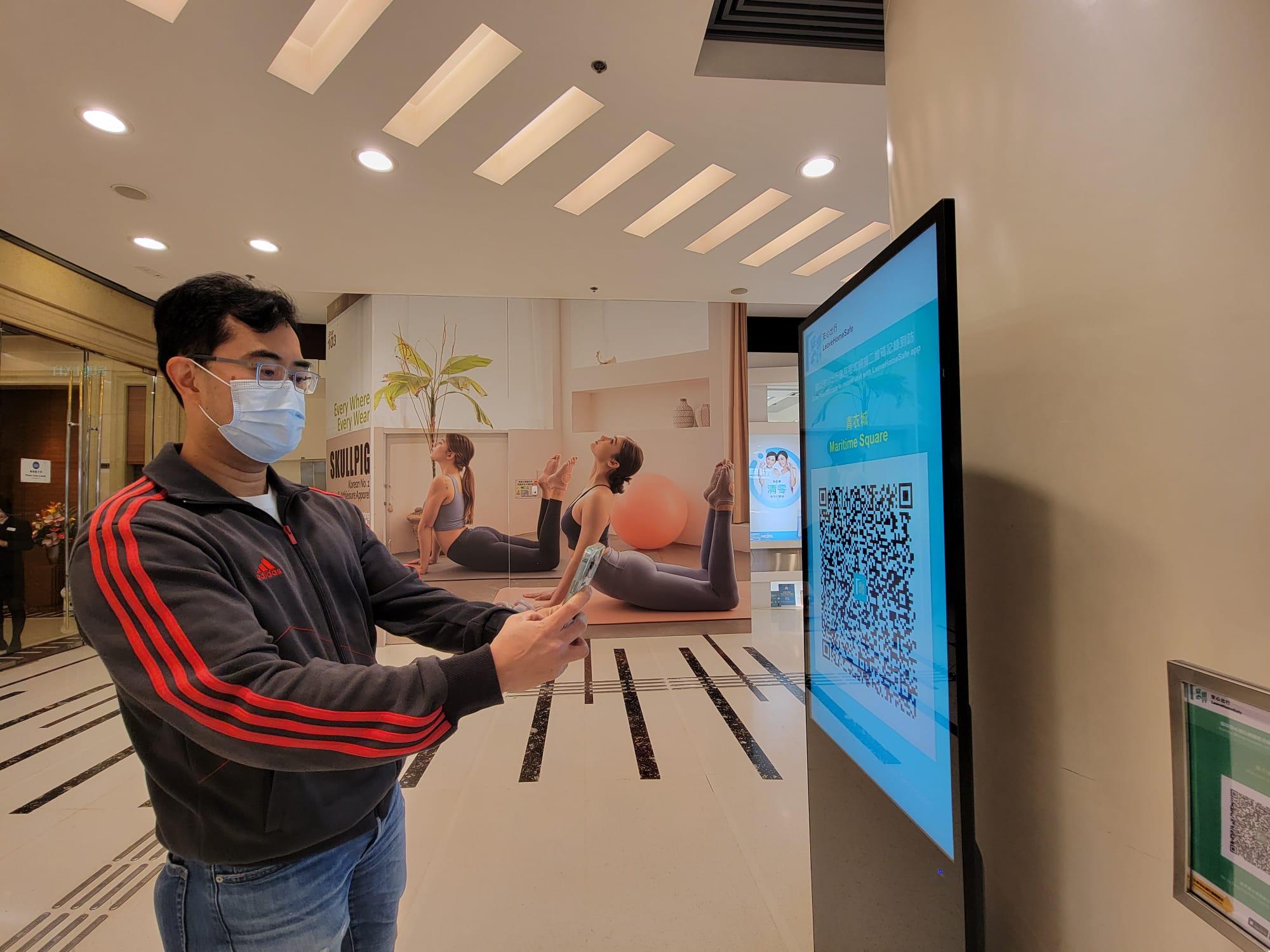 「疫苗通行證」今日生效,青衣城以電子屏幕展示「安心出行」二維碼。(莊振邦攝)