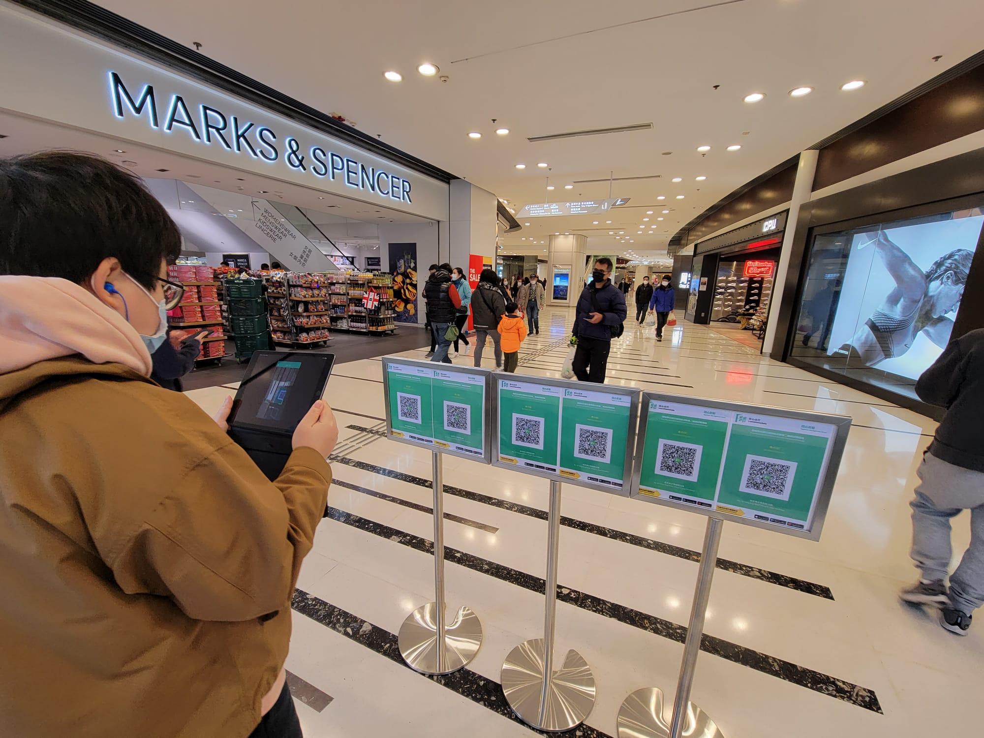 「疫苗通行證」今日生效,青衣城在入口擺放多個「安心出行」二維碼。(莊振邦攝)