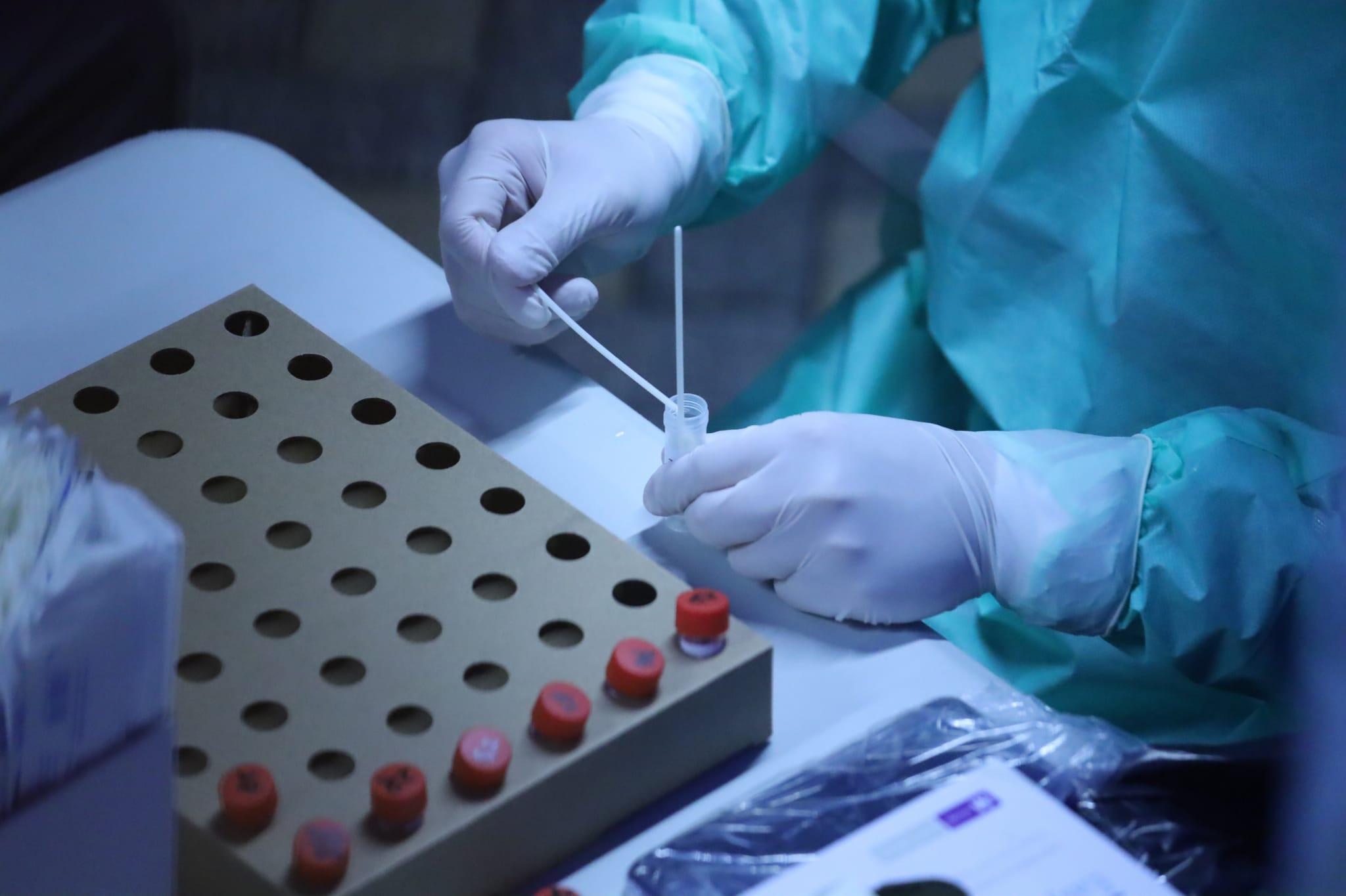 在秀茂坪邨秀賢樓圍封區域,有職員處理採集的樣本。(鍾式明攝)