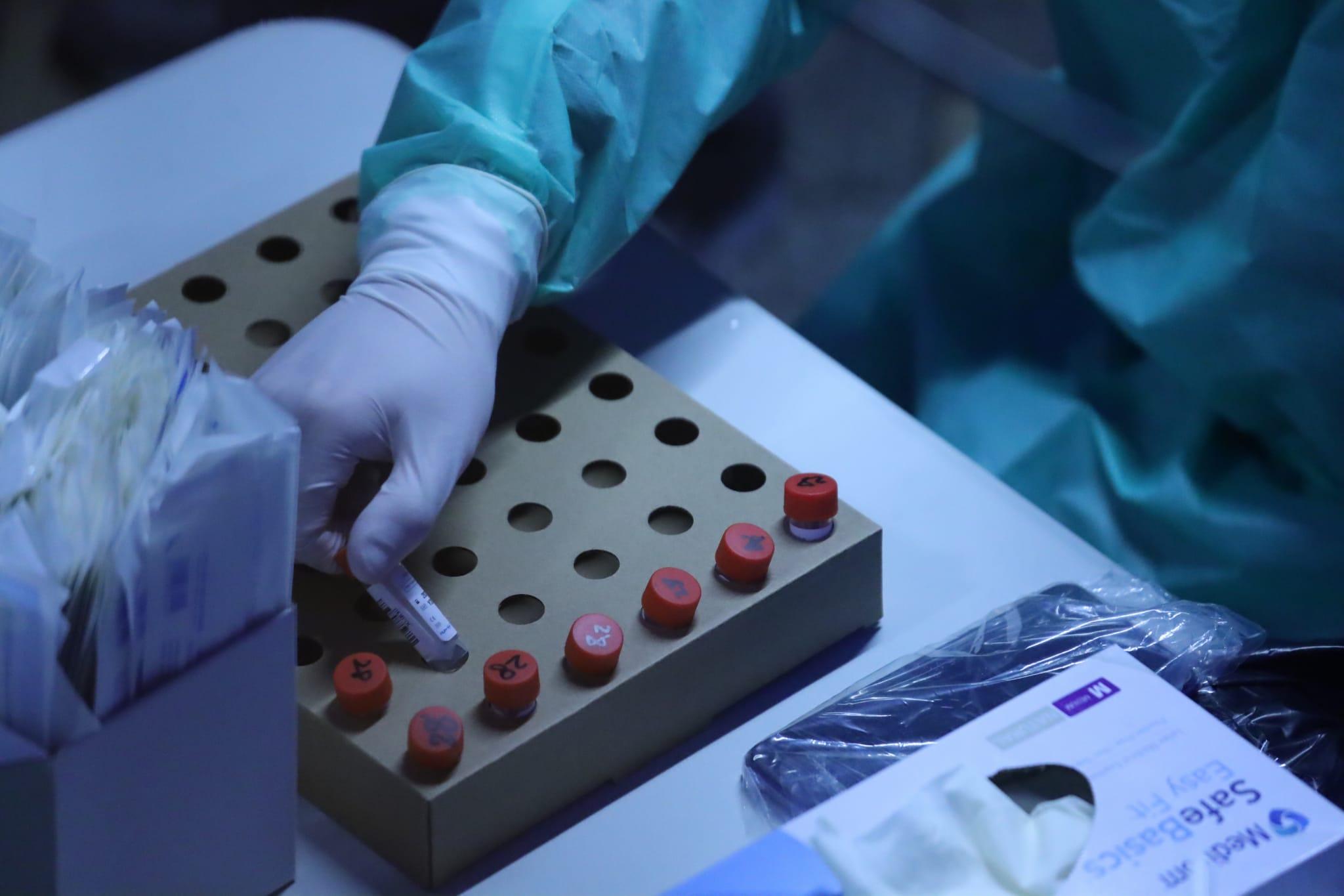 在秀茂坪邨秀賢樓圍封區域,有職員處理採集的樣本。(鍾式明攝)