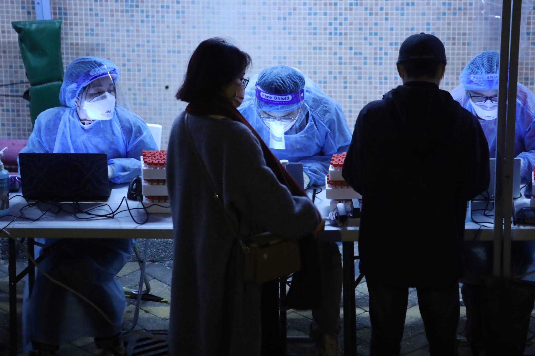 秀茂坪邨秀賢樓居民晚上落樓登記檢測。(鍾式明攝)