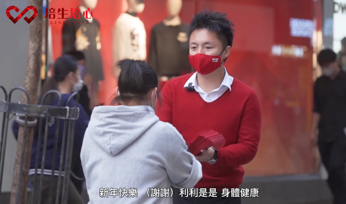 鍾培生向途人派利是。