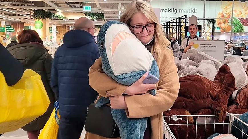 新西伯利亞的IKEA店,一位戴着眼鏡的女子攬著IKEA知名毛公仔「BLAHA」依依不捨。(網上圖片)