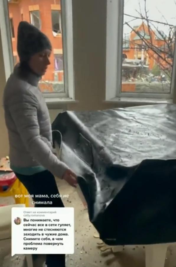 女子揭開用作遮蓋鋼琴的帆布,上面滿是塵土。(Twitter)