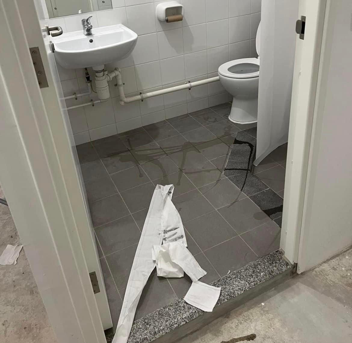 廁所地板有廁紙及不明水漬。(香港抗疫關注組@fb圖)