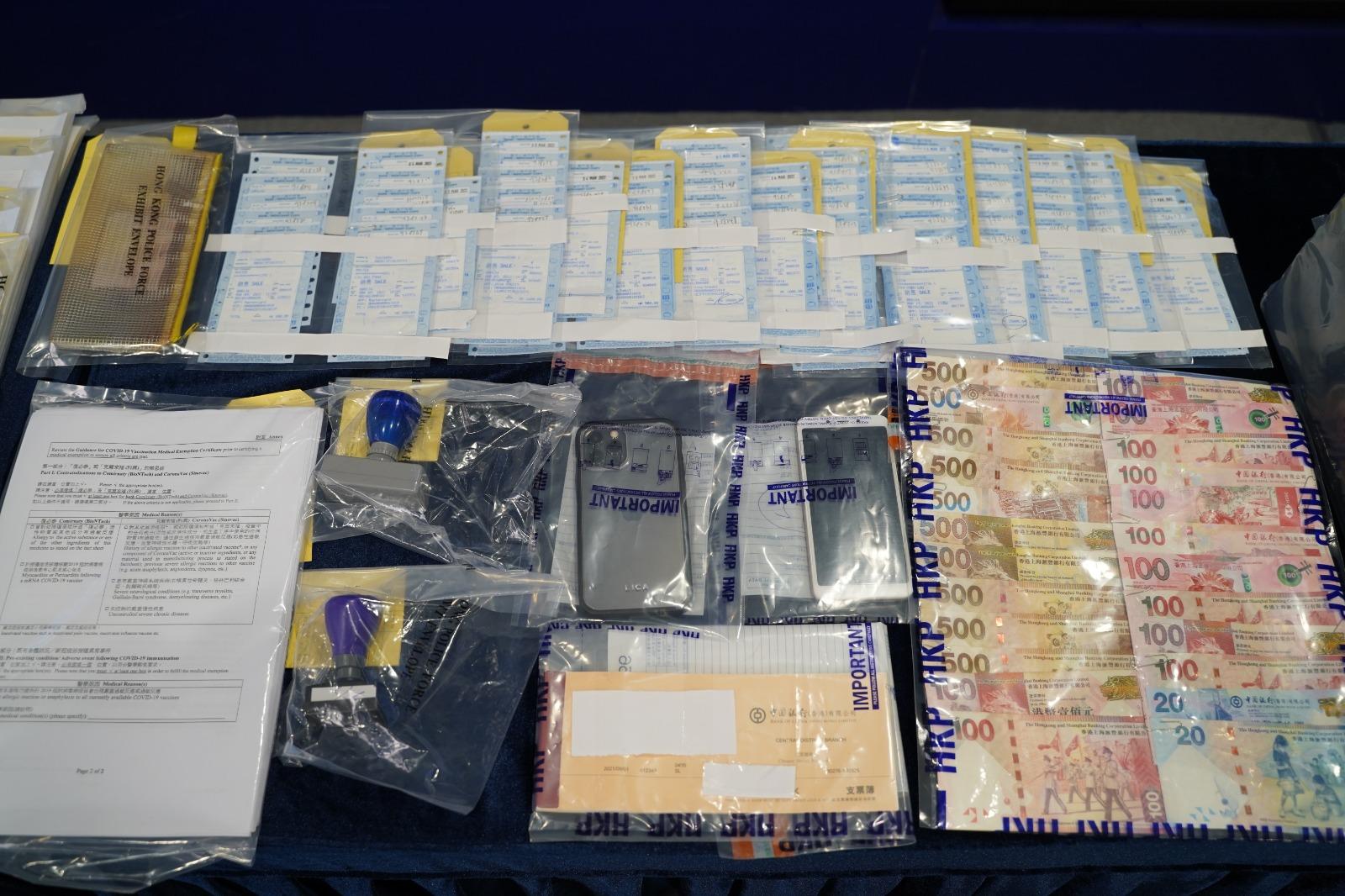 警方展示檢獲的物品,包括手提電話及一批現金。(警方圖片)
