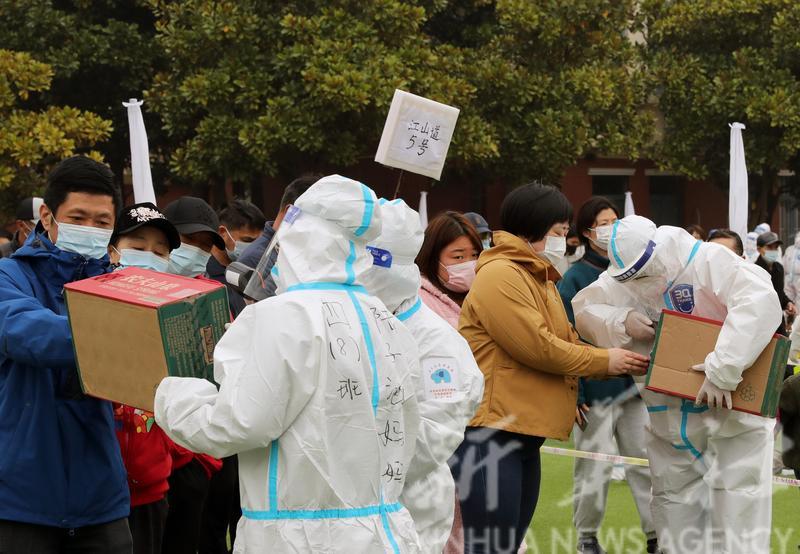 工作人員將廢紙箱用作遮擋光綫的掃碼箱,避免屏幕反光,提高掃碼效率。(新華社圖)