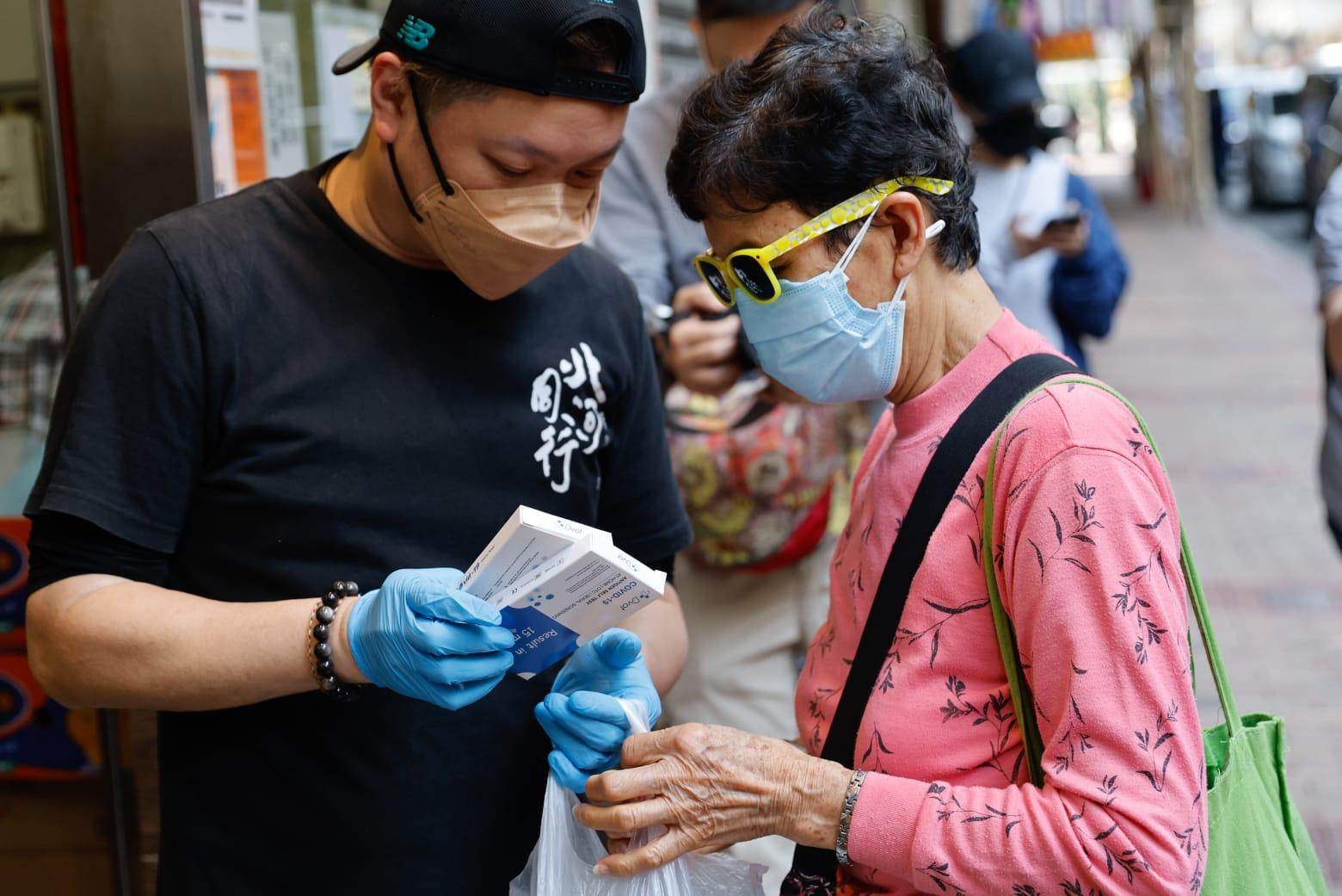 新世界送贈深水埗明哥快速測檢包,讓明哥派飯同時,亦送出急切的抗疫物資。(蘇文傑攝)