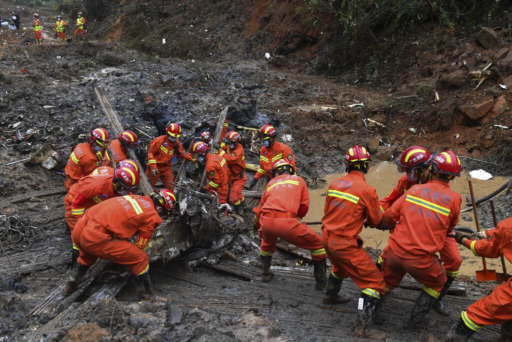 搜索人員掘起失事的東航客機部件。