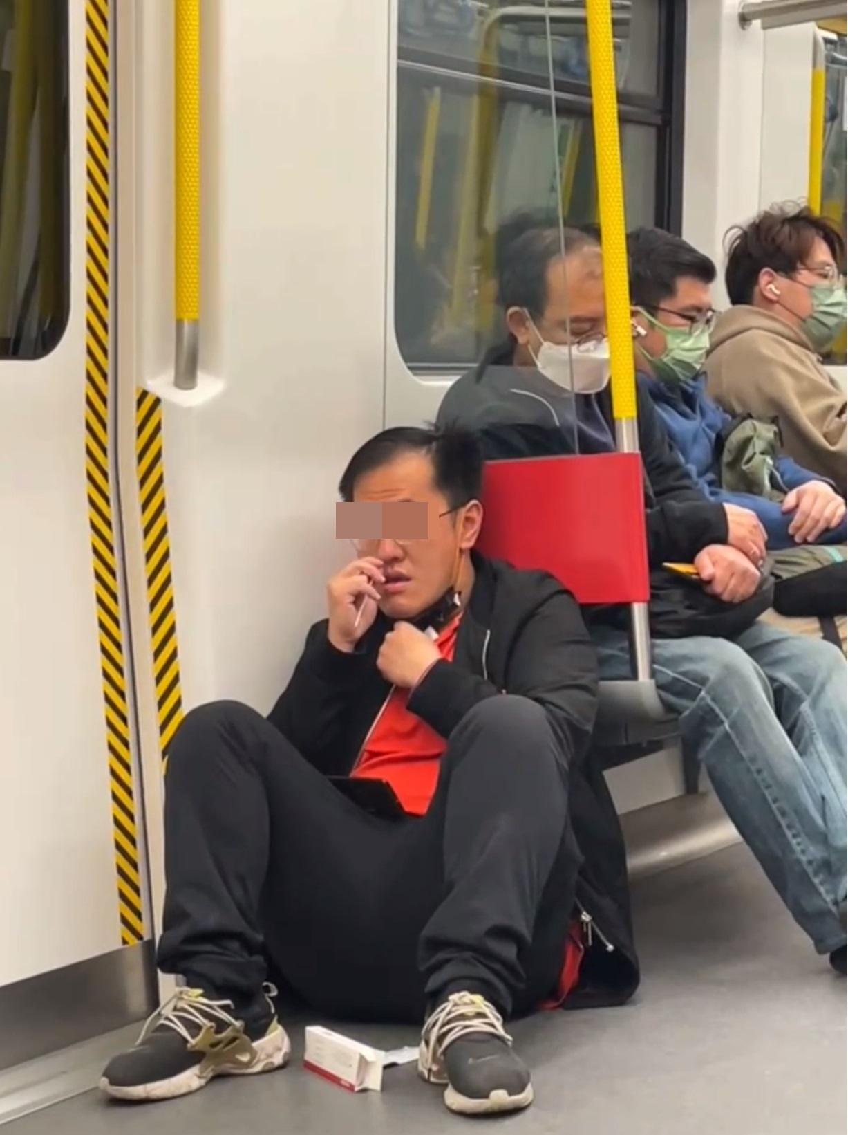 一名中年男子在港鐵車廂除口罩做快速檢測。(網片截圖)