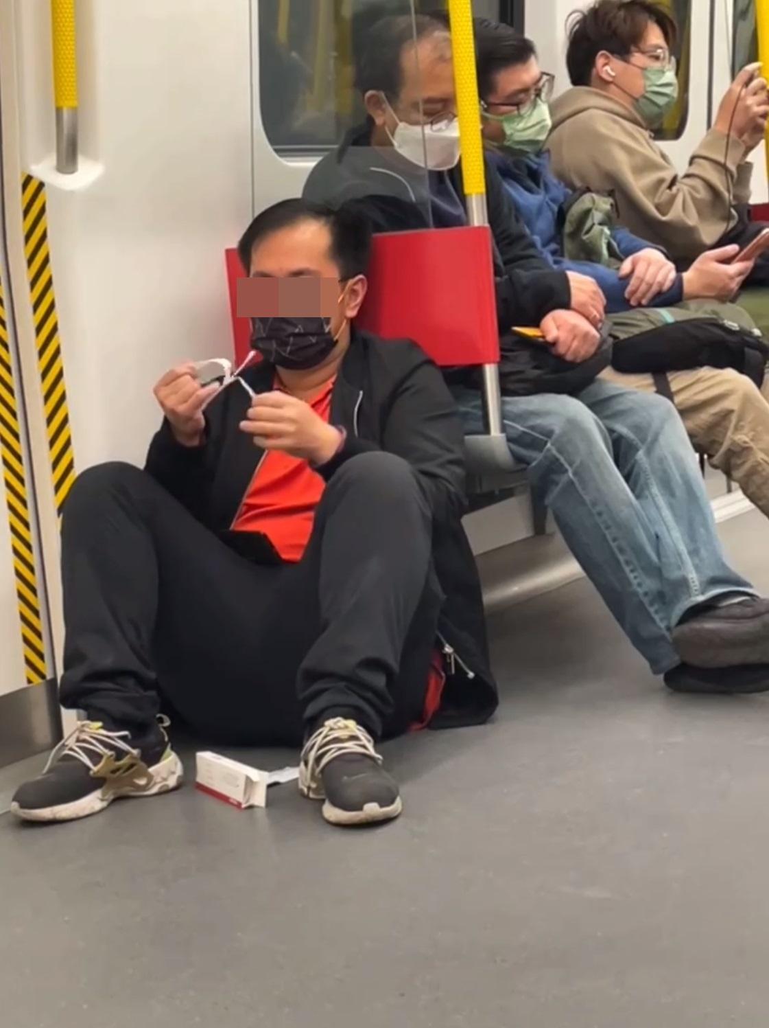 一名中年男子在港鐵車廂除口罩做快速檢測。(網片截圖)