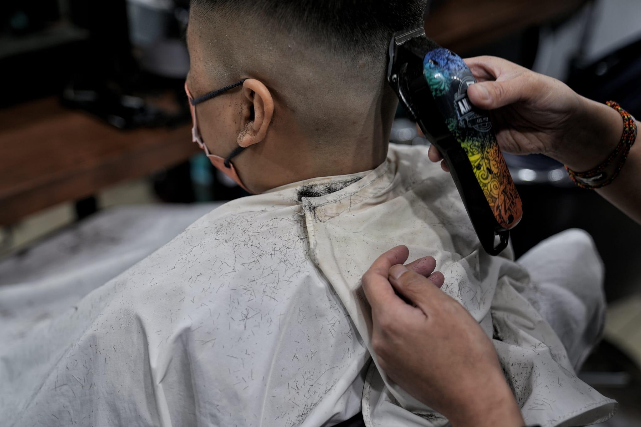 髮型屋及理髮店今日重開,顧客須掃描「安心出行」及出示針卡。(夏家朗攝)