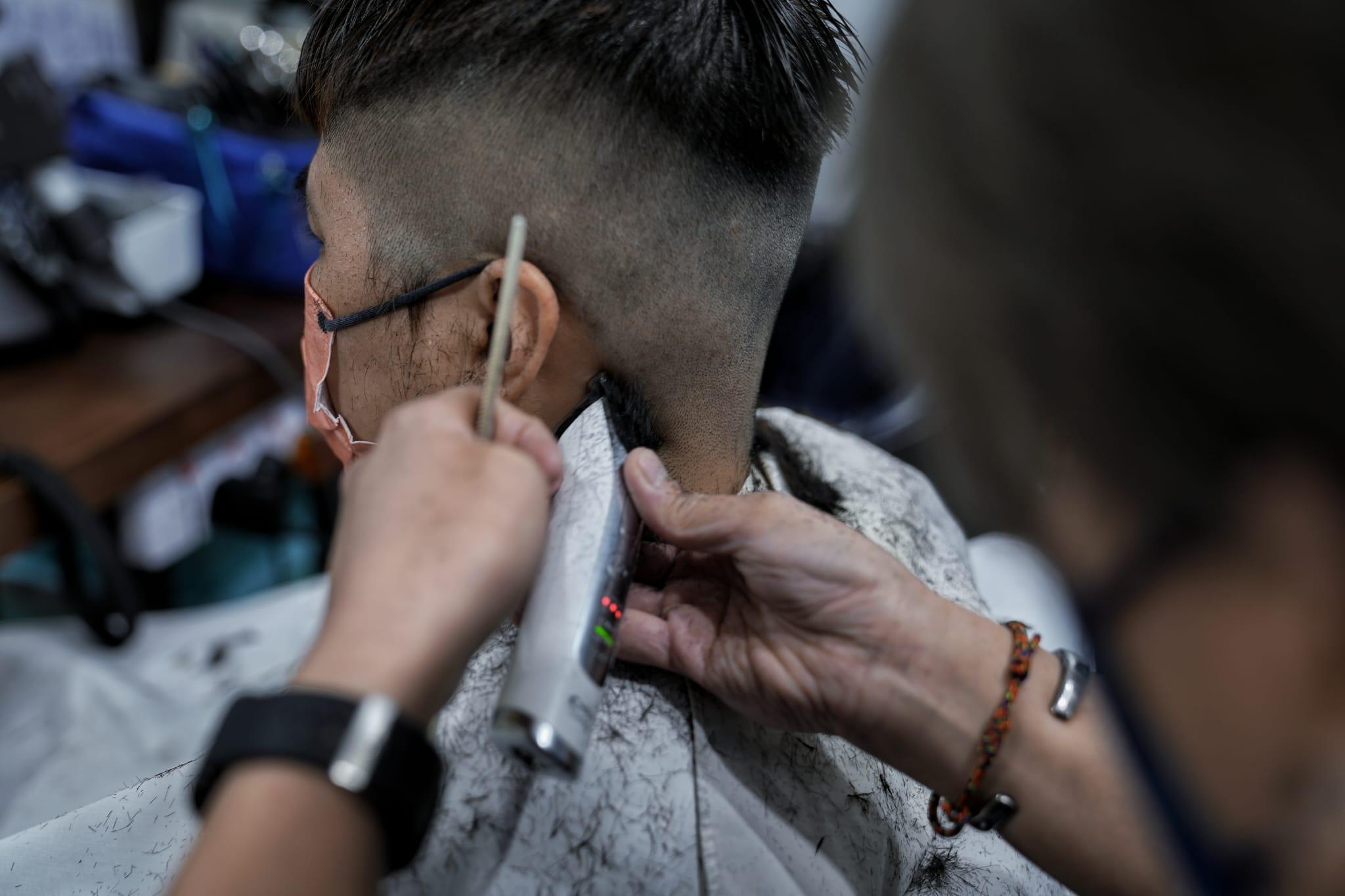 髮型屋及理髮店今日重開,顧客須掃描「安心出行」及出示針卡。(夏家朗攝)