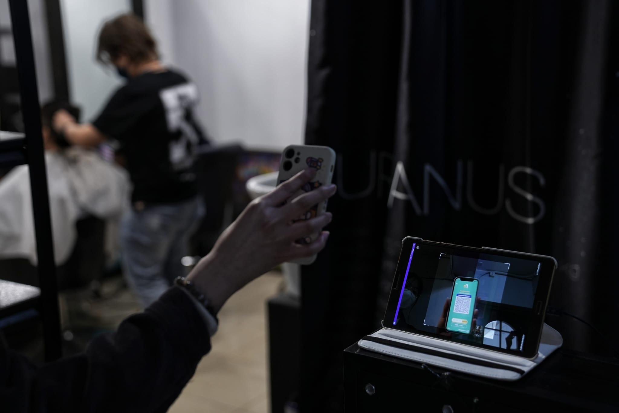 髮型屋及理髮店今日重開,顧客須掃描「安心出行」及出示針卡。(夏家朗攝)