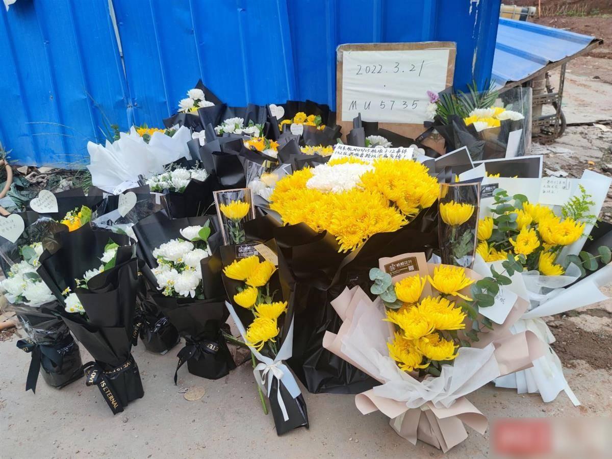 東航墜機封鎖區外圍擺滿民眾悼念鮮花和卡片。(互聯網)