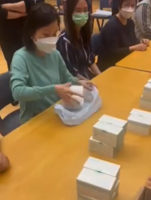 第二名職員放入4盒物資。(公務員secrets Facebook 影片截圖)