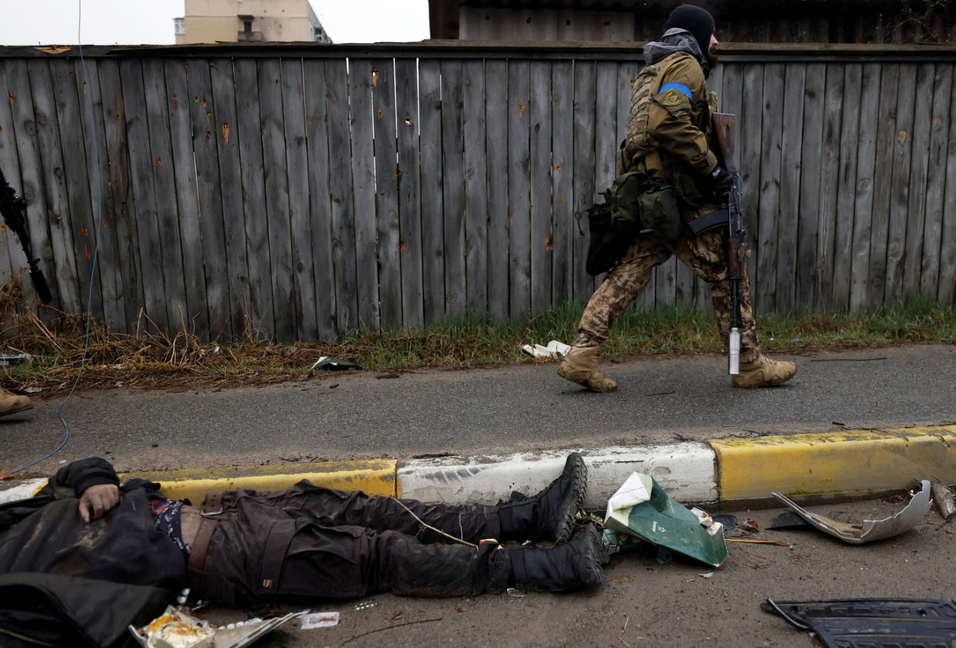烏軍經過Bucha街上一具平民遺體。(路透社)