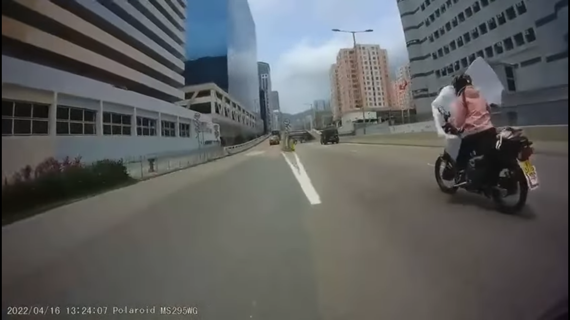 掛着學牌的女騎士在路上被垃圾阻礙視線。(影片截圖)