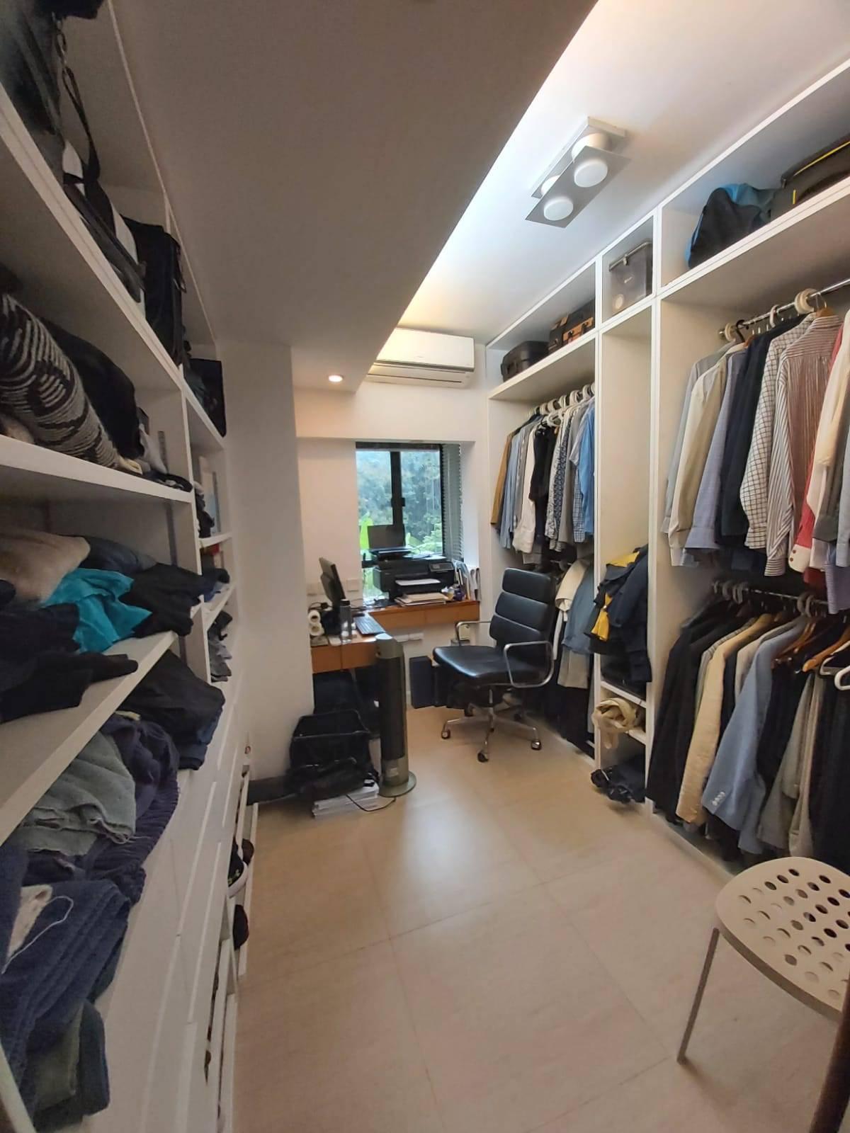 另一個房間用作衣帽間,內置置頂層架和衣櫃,方便收納。