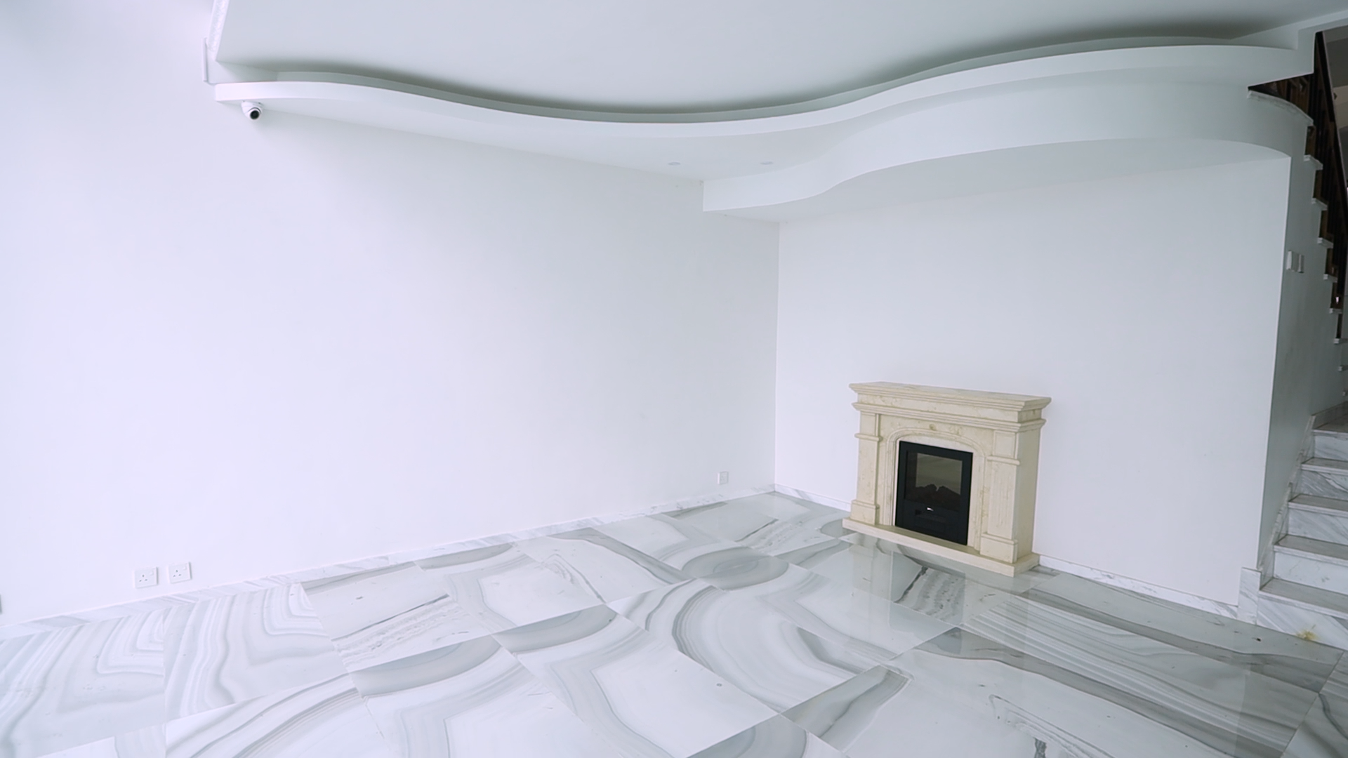 客廳設有仿璧爐,配合白色綴灰色紋理的雲石地板,以及流線形假天花,傳統的獨立大宅格調。