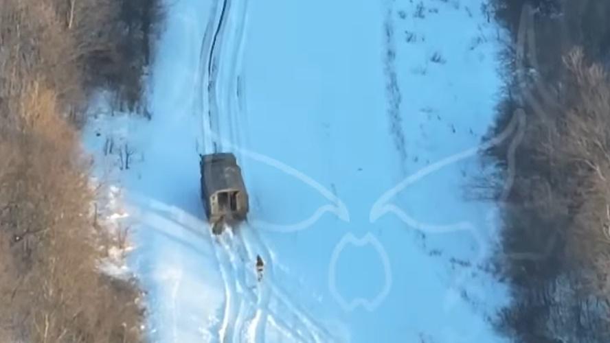 2名俄兵在車後狂奔追趕,但軍車似乎沒有停下的動作,直駛上一條大斜坡。(FB)