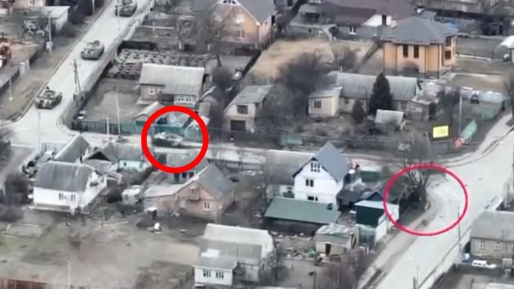 平民推著單車轉入有俄軍車停留的街道。(Twitter)