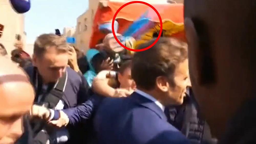 馬克龍險被民眾投擲的車厘茄擲中,在場保安一度開雨傘掩護。(Twitter)