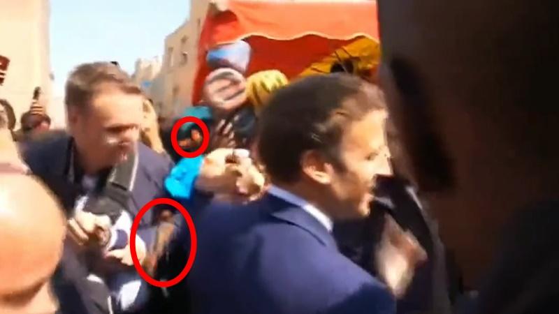 馬克龍險被民眾投擲的車厘茄擲中,在場保安一度開雨傘掩護。(Twitter)