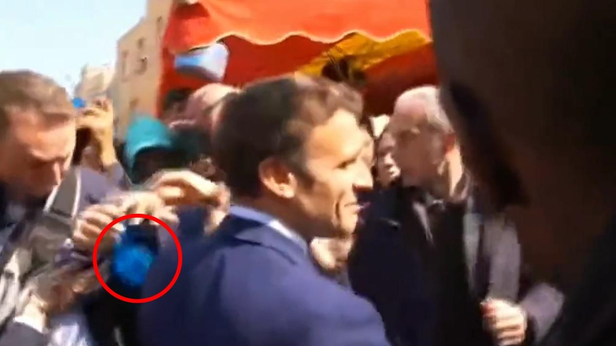 馬克龍險被民眾投擲的車厘茄擲中,在場保安一度開雨傘掩護。(Twitter)
