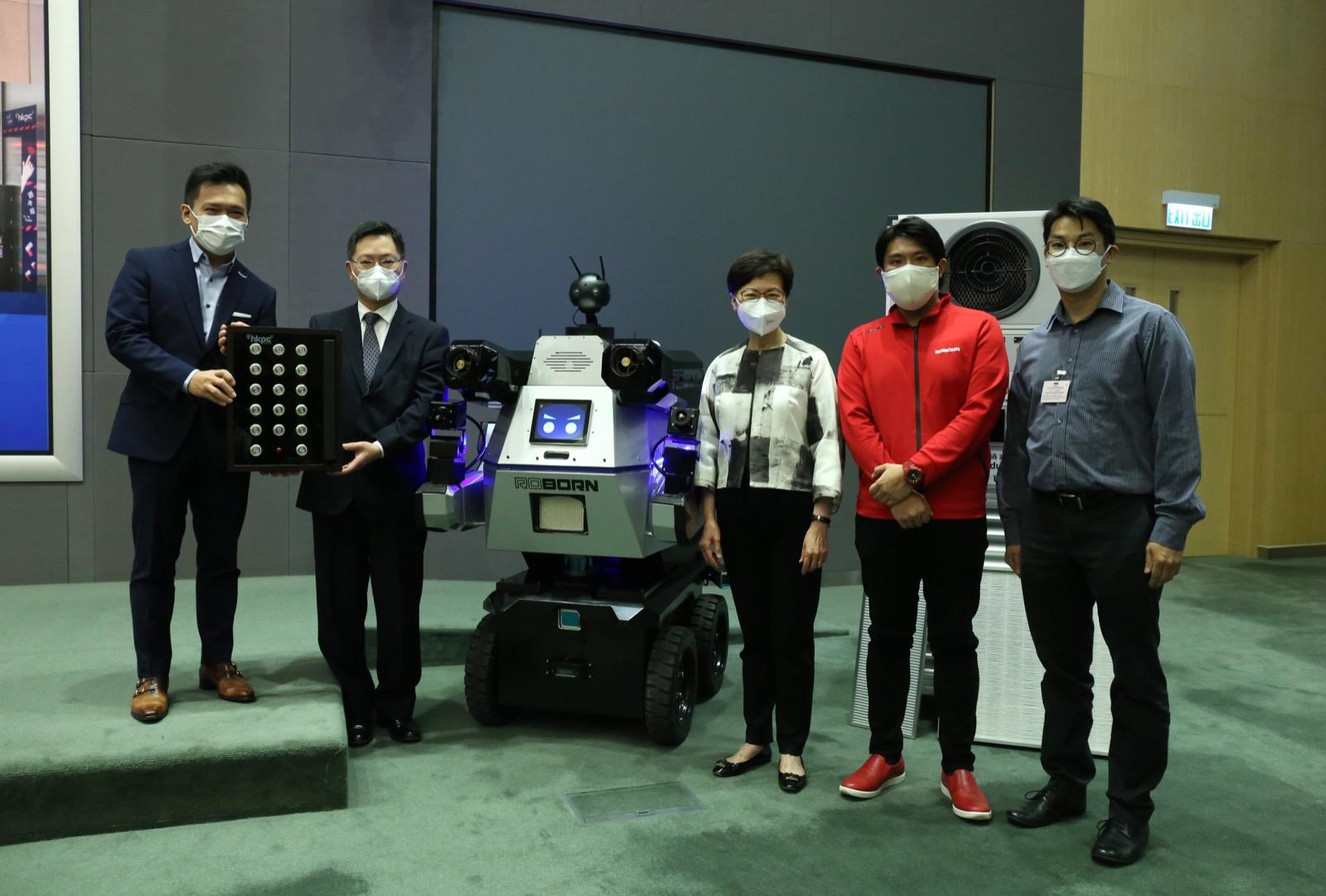 特首林鄭月娥與創科局長薛永恒與抗疫科技產品合照。