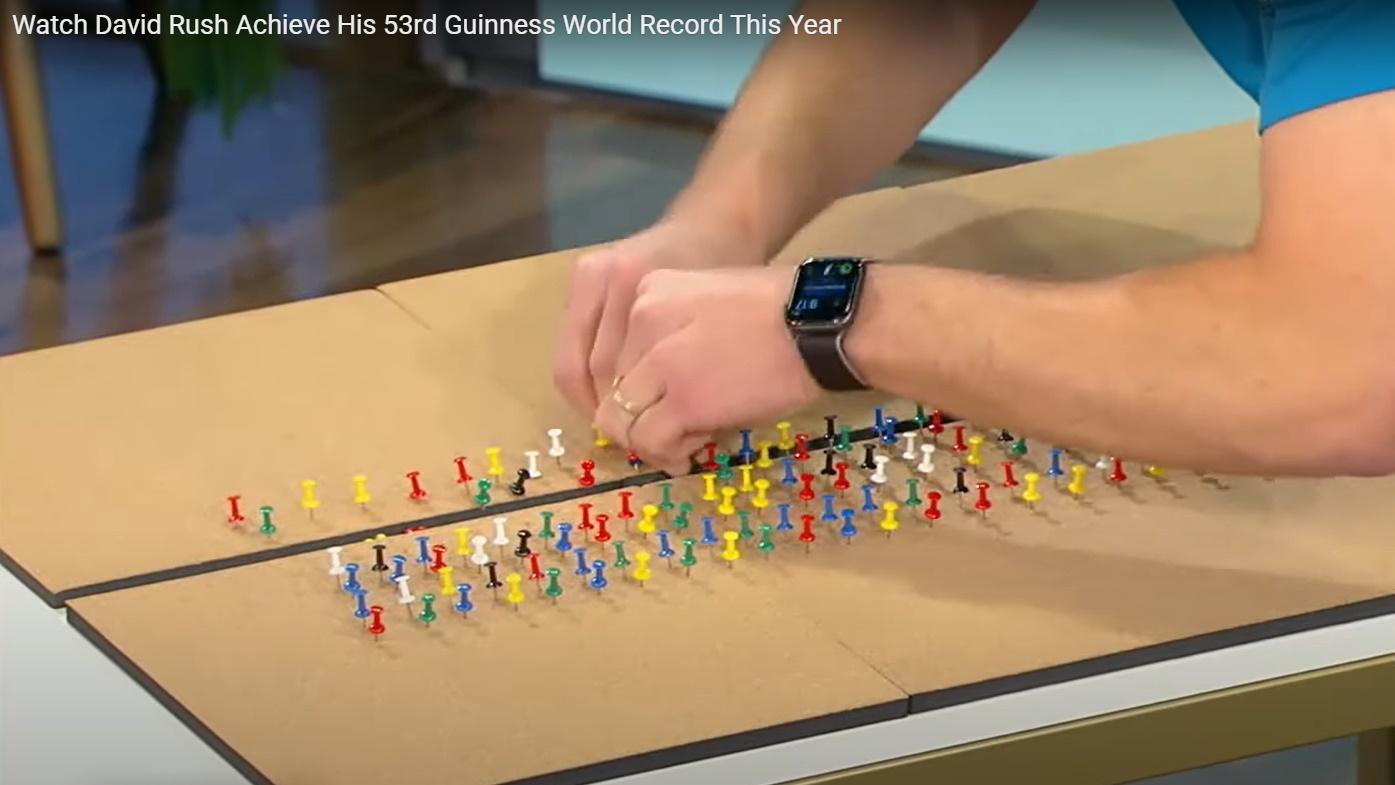 David Rush在1分鐘內用雙手將180 粒圖釘推入木板。(YouTube)