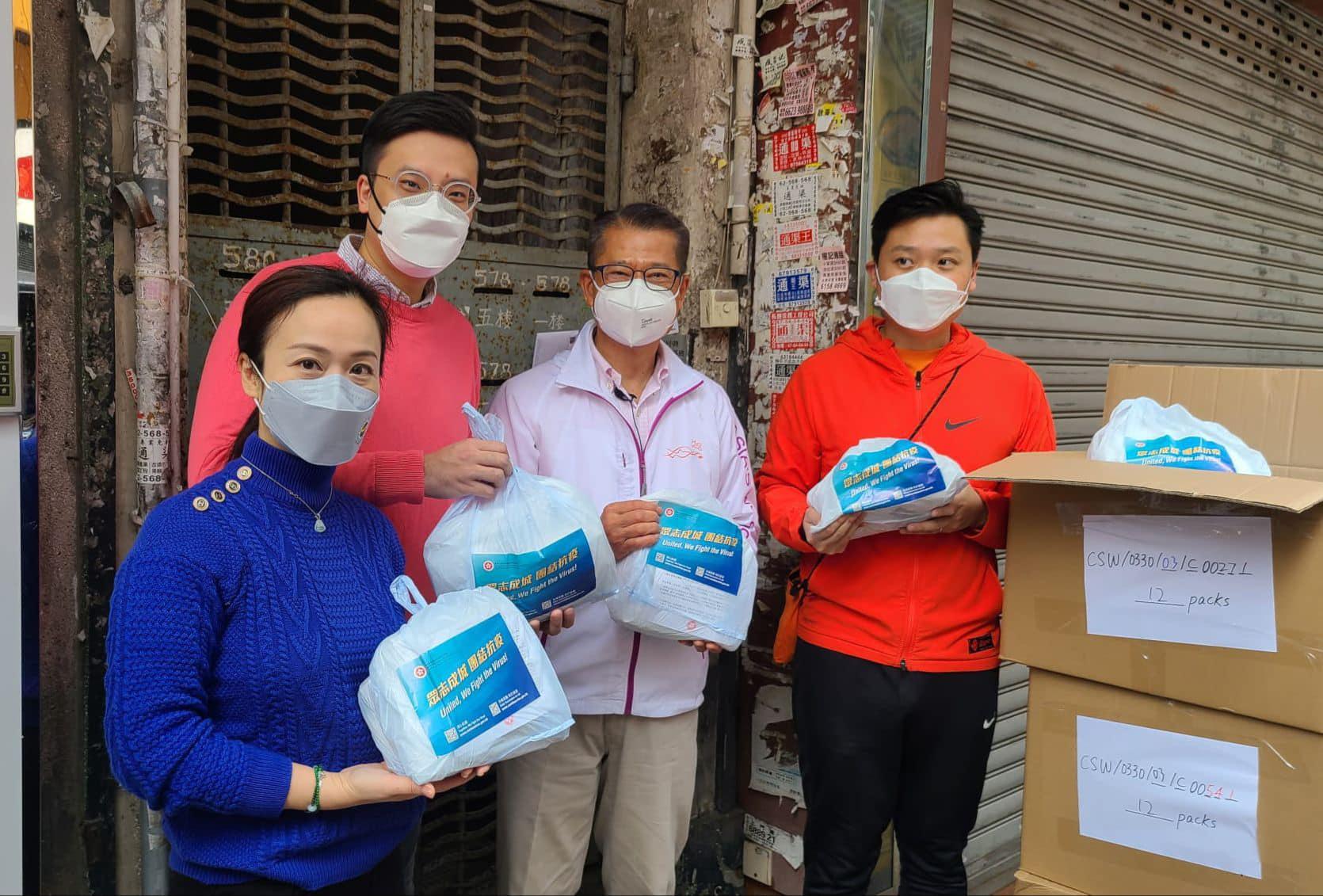 財政司長陳茂波(右二)到深水埗「三無」大廈派發「防疫服務包」。(陳凱欣 Facebook)