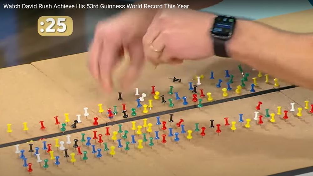 David Rush在1分鐘內用雙手將180 粒圖釘推入木板。(YouTube)